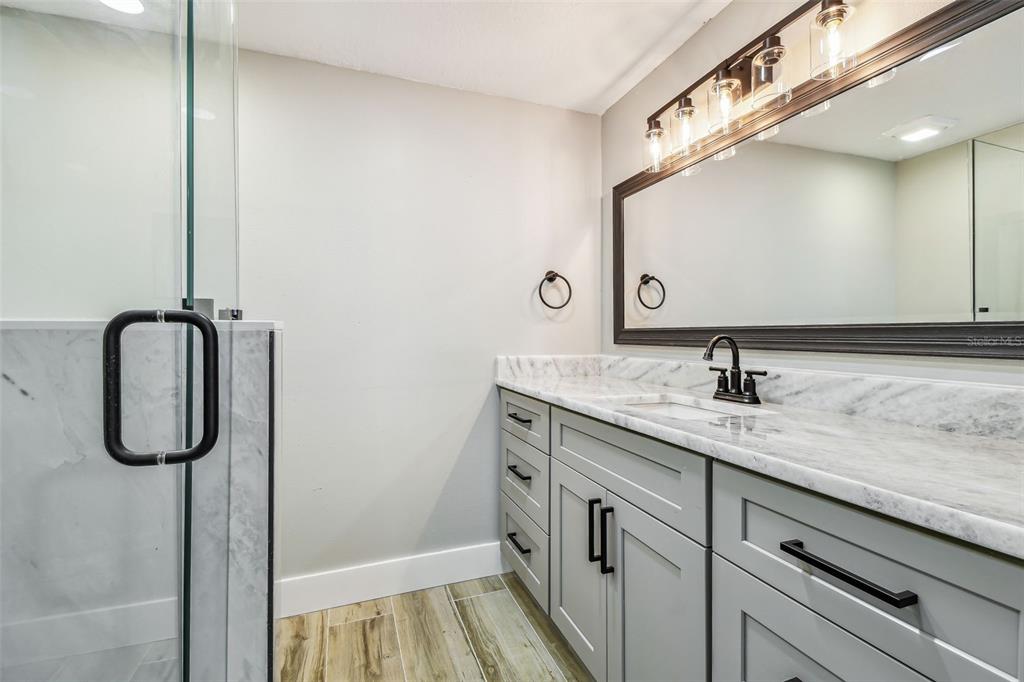 13909 Berkowitz Avenue Hudson, FL 34667 - Photo 33 of 91 a bathroom with a granite countertop sink and a mirror