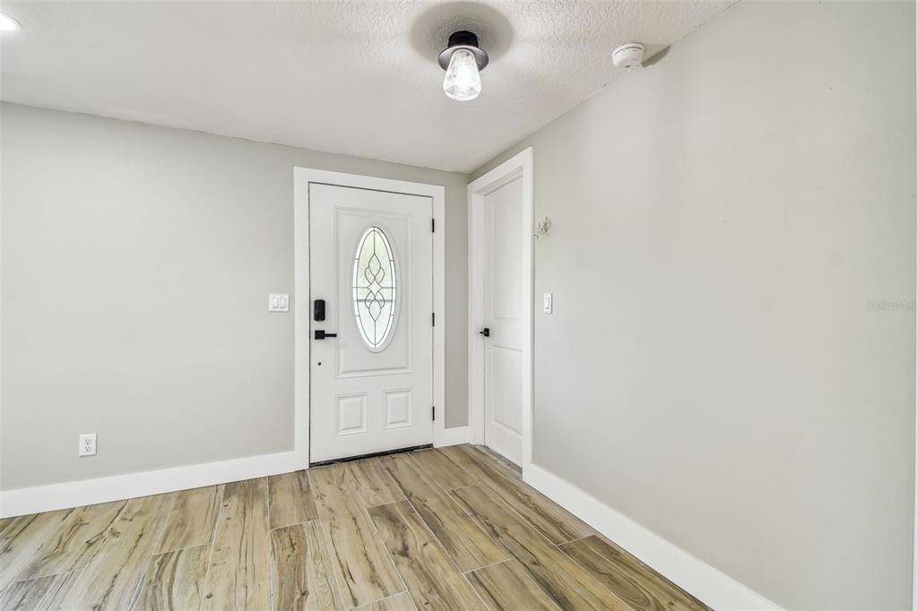 13909 Berkowitz Avenue Hudson, FL 34667 - Photo 7 of 91 an empty room with wooden floor and windows