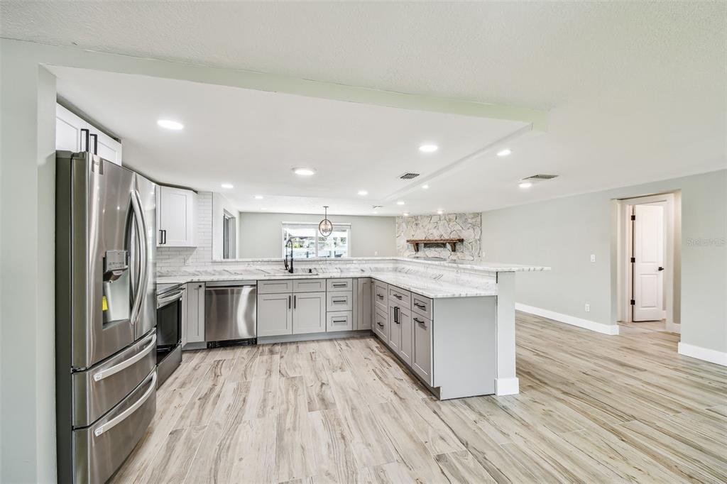 13909 Berkowitz Avenue Hudson, FL 34667 - Photo 8 of 91 a large kitchen with a center island wooden floor stainless steel appliances and cabinets