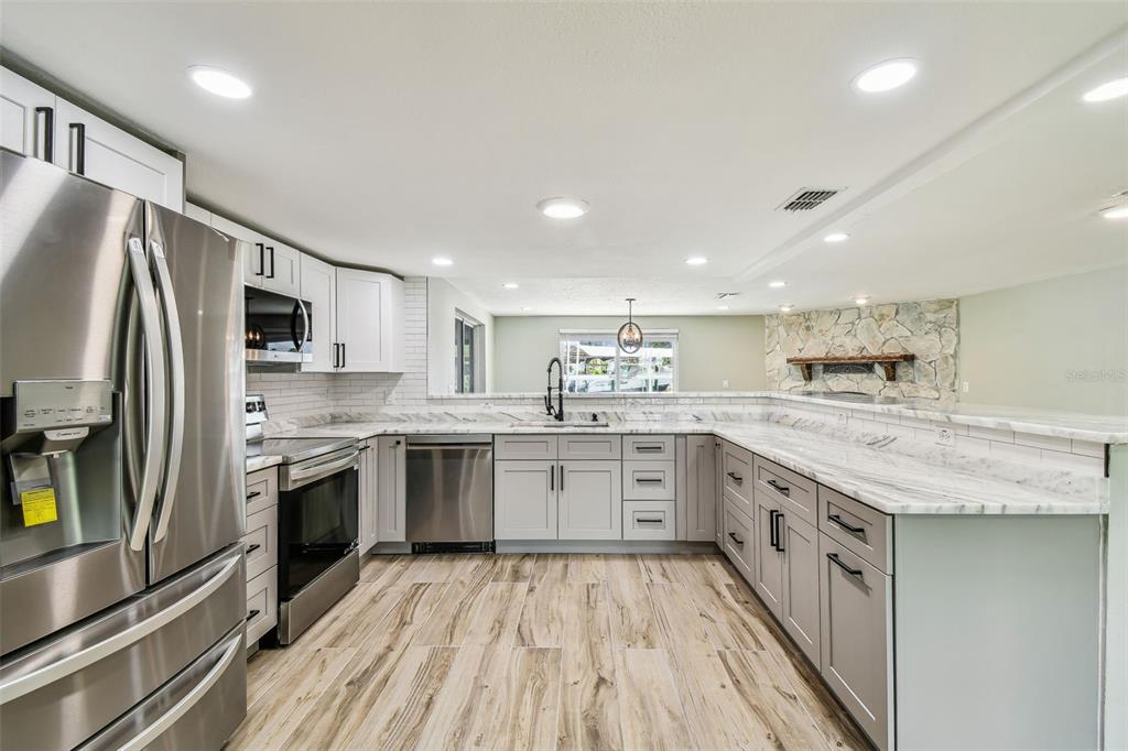 13909 Berkowitz Avenue Hudson, FL 34667 - Photo 9 of 91 a kitchen with stainless steel appliances granite countertop refrigerator sink and stove