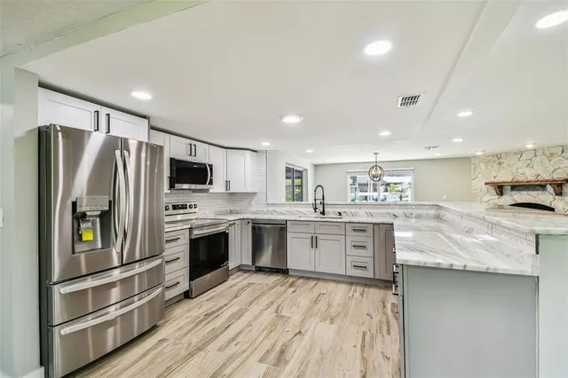 a kitchen with stainless steel appliances granite countertop a stove and a sink