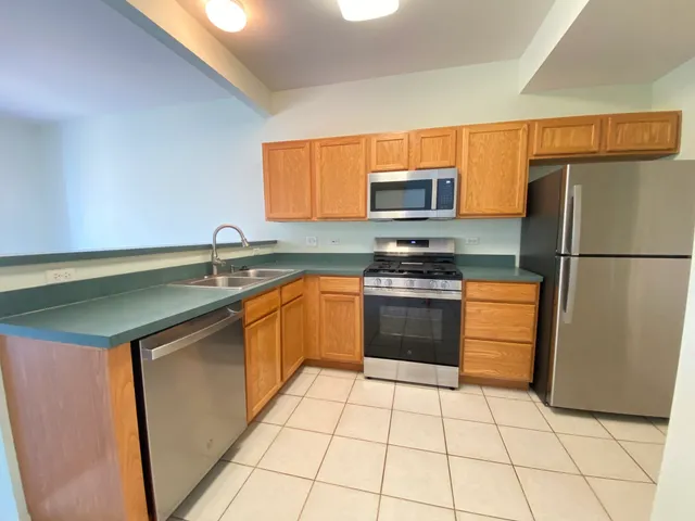 a kitchen with stainless steel appliances granite countertop a refrigerator sink and stove