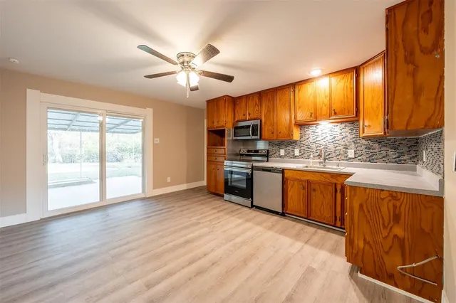 a kitchen with stainless steel appliances kitchen island granite countertop a stove a sink and a refrigerator