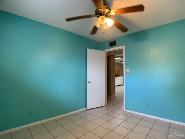 an empty room with closet and fan