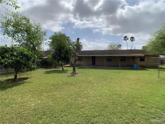 a green field with lots of trees in the background