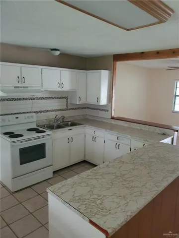 a kitchen with granite countertop white cabinets and white stainless steel appliances