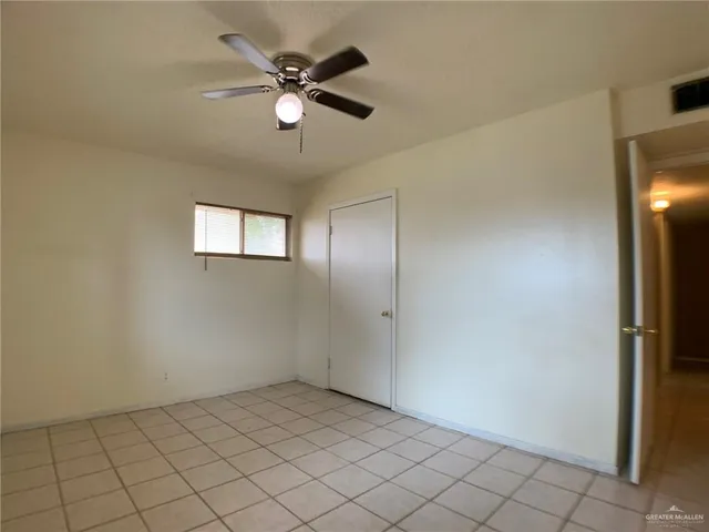 an empty room with windows and fan