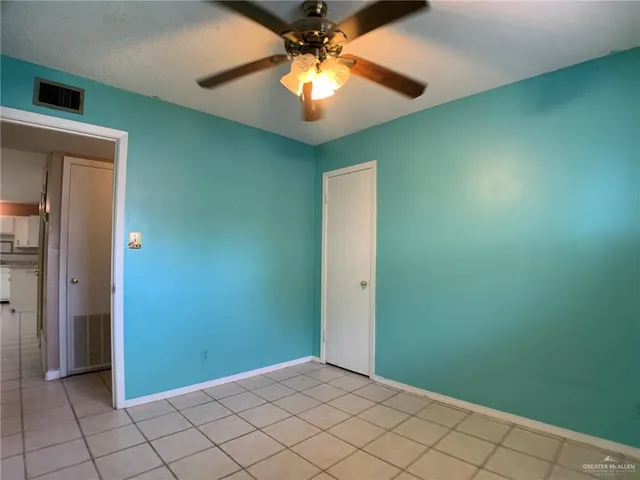 an empty room with chandelier fan