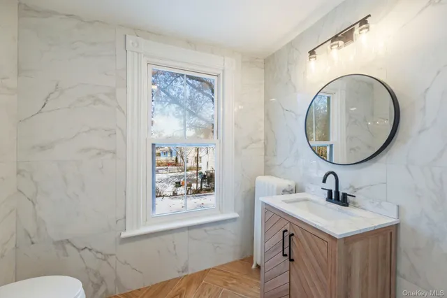 a bathroom with a sink vanity mirror and toilet