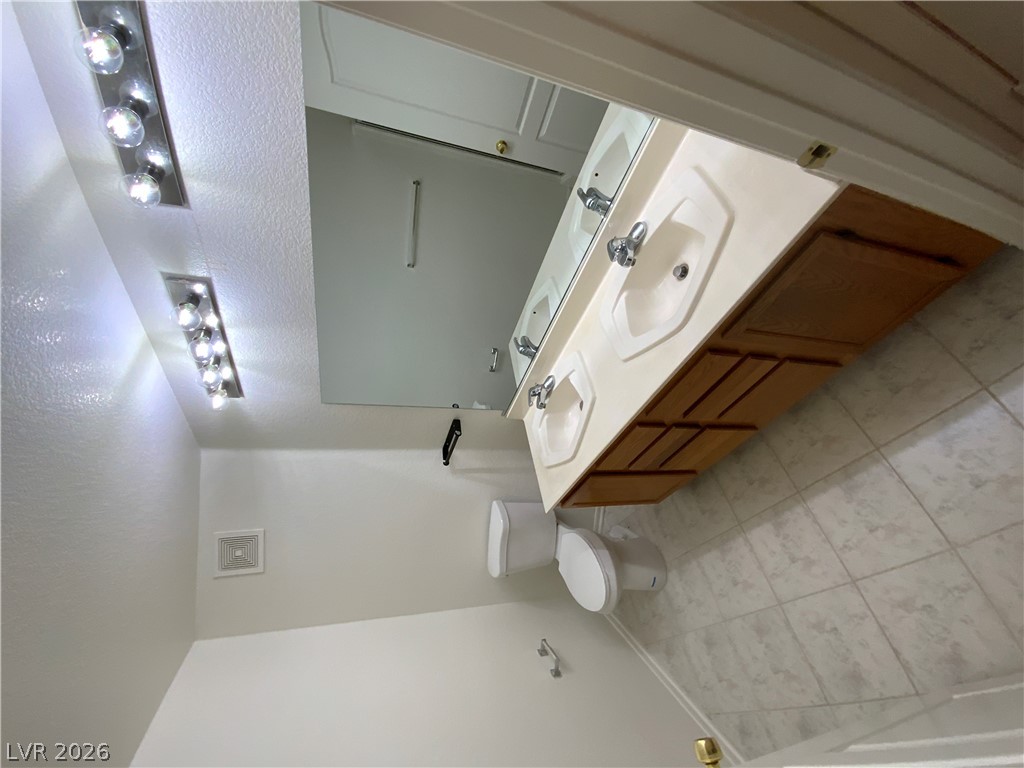 7400 West Flamingo Road, Unit 1039 Las Vegas, NV 89147 - Photo 27 of 40 Double vanity sinks and bright lighting create a functional and well-appointed bathroom space.