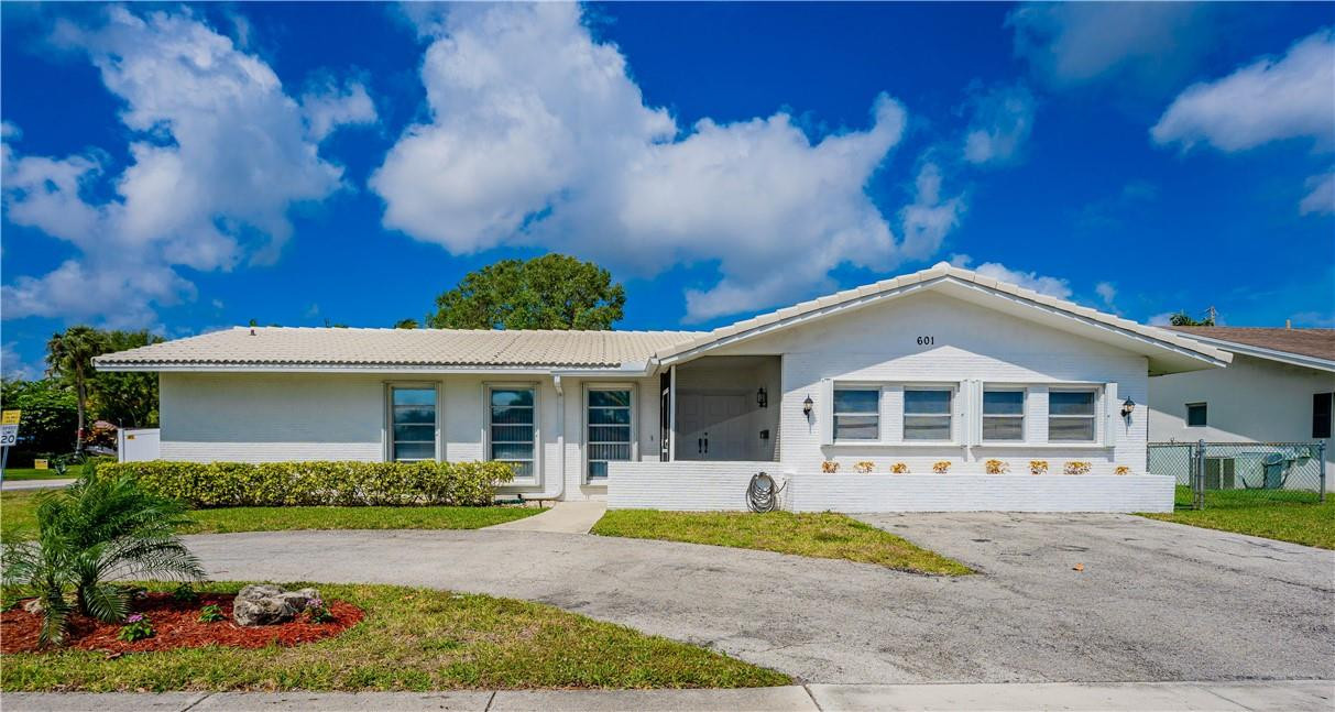a front view of a house with a yard and potted plants