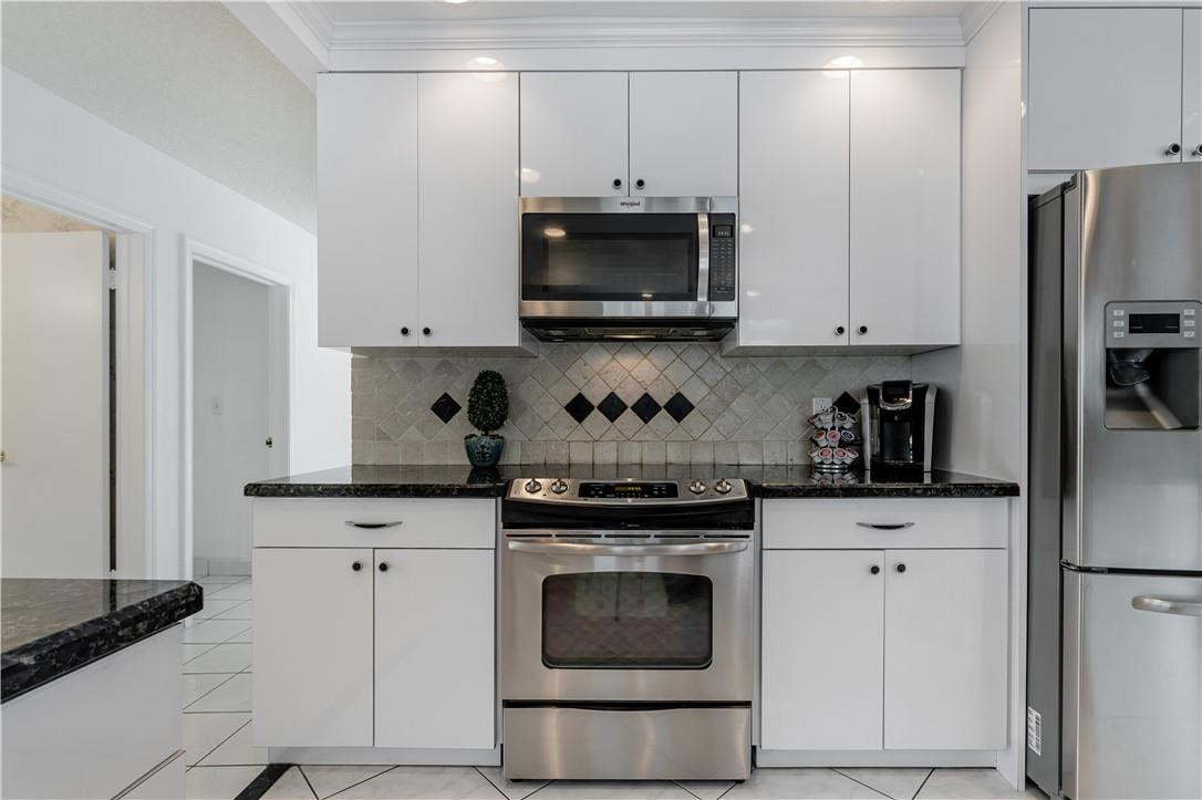 601 Northwest 12th Avenue Boca Raton, FL 33486 - Photo 11 of 27 a kitchen with white cabinets and stainless steel appliances