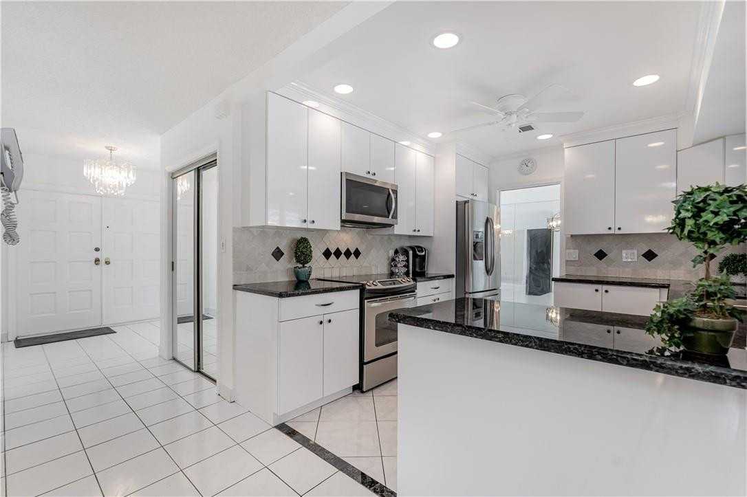 601 Northwest 12th Avenue Boca Raton, FL 33486 - Photo 12 of 27 a kitchen with granite countertop a refrigerator and a stove top oven