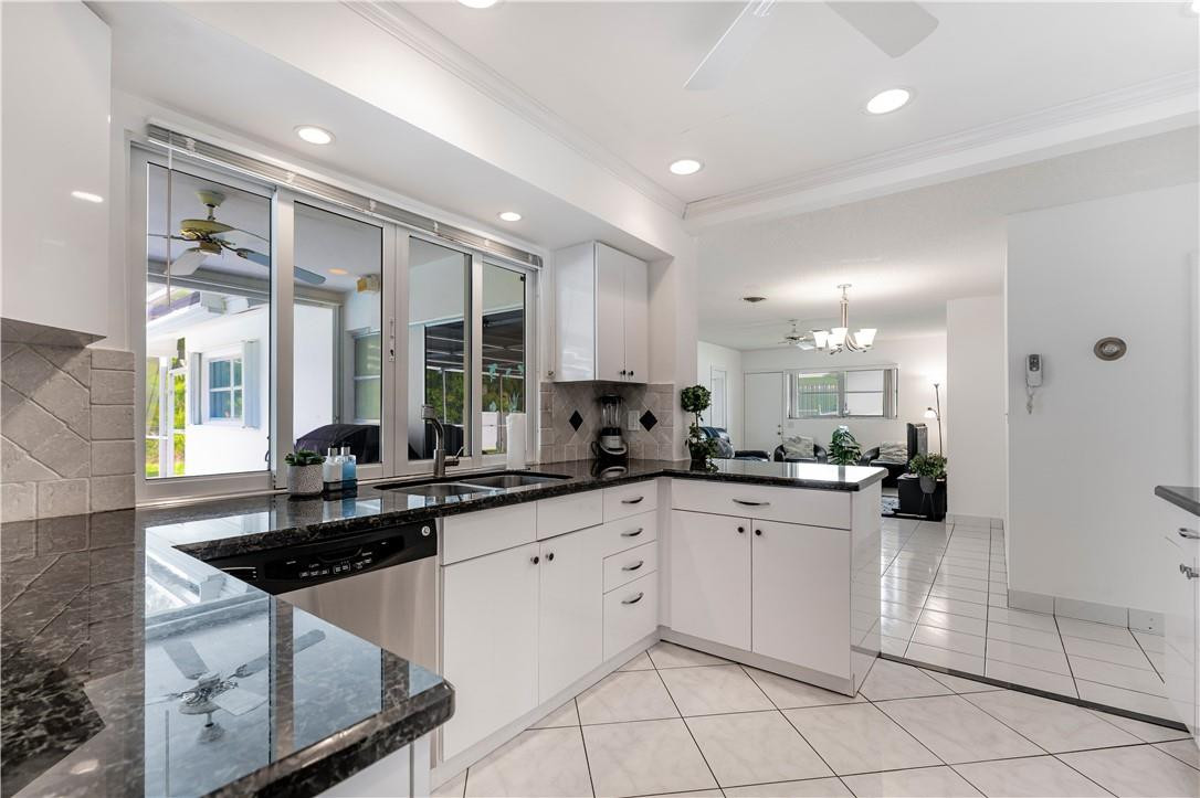 601 Northwest 12th Avenue Boca Raton, FL 33486 - Photo 9 of 27 a kitchen with stainless steel appliances granite countertop a sink and cabinets