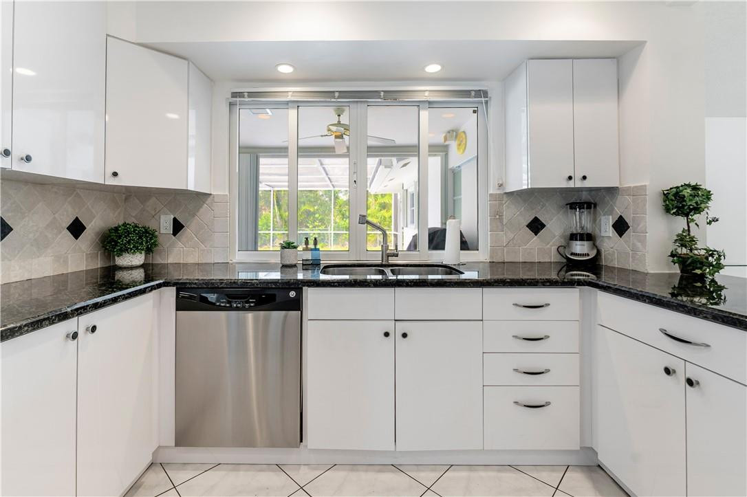 601 Northwest 12th Avenue Boca Raton, FL 33486 - Photo 10 of 27 a kitchen with granite countertop white cabinets and white appliances