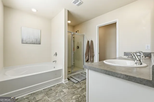 a bathroom with a granite countertop sink a mirror and a bathtub