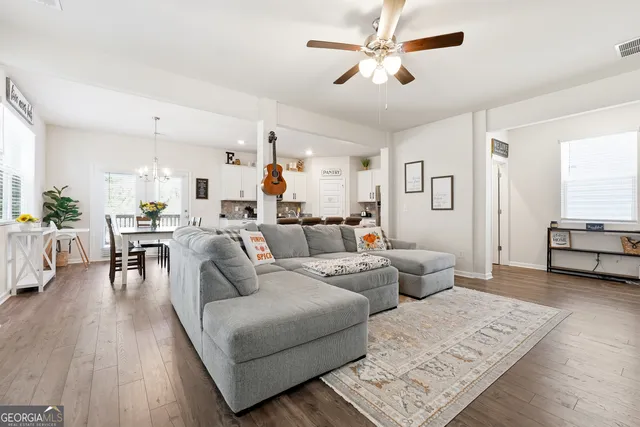 a living room with furniture and wooden floor