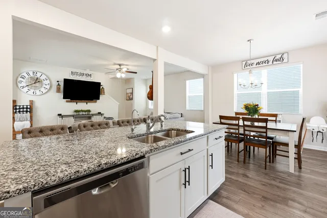 a view of a kitchen with kitchen island granite countertop a sink and a stove top oven