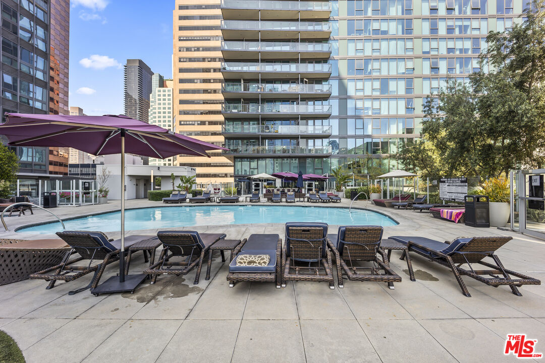 901 Flower Street, Unit 700 Los Angeles, CA 90015 - Photo 27 of 55 a view of a patio with table and chairs under an umbrella