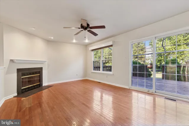 a view of empty room with wooden floor and fireplace