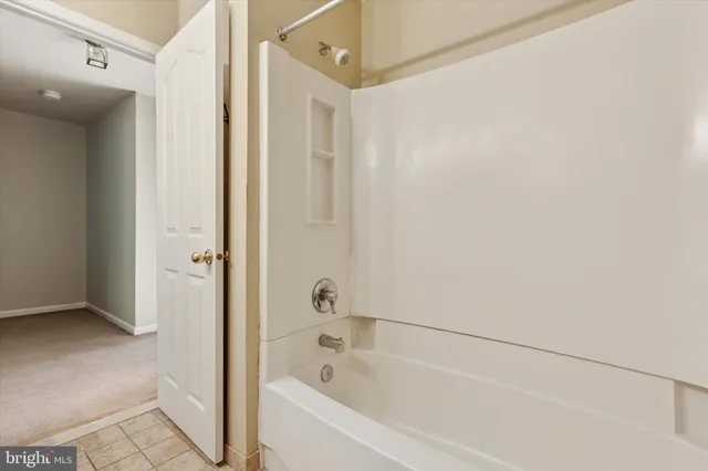 a white bath tub sitting next to a shower
