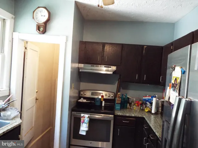 a kitchen with stainless steel appliances granite countertop a refrigerator and a stove