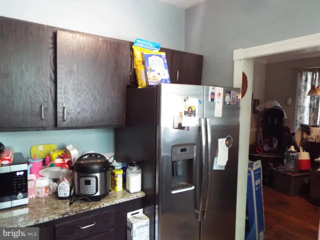 a kitchen with a refrigerator and a stove top oven