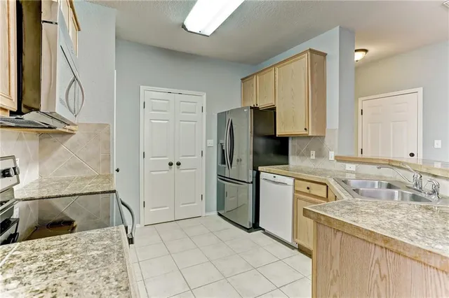 a kitchen with a sink cabinets and refrigerator