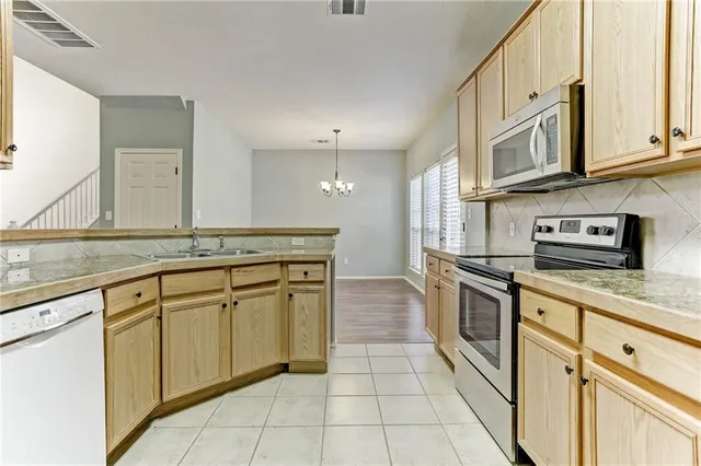 a large kitchen with stainless steel appliances granite countertop a stove and a sink
