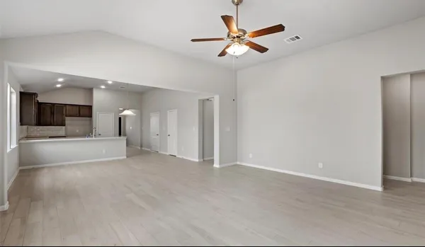an empty room with a view of a kitchen