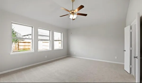 an empty room with window and ceiling fan