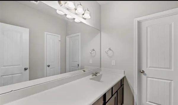 a bathroom with a sink a light fixture and a mirror