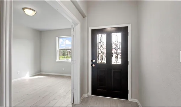 a view of an empty room with glass door and a window