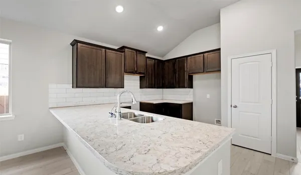 a kitchen with kitchen island a sink and refrigerator