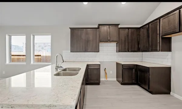 a kitchen with granite countertop a stove a sink and a microwave