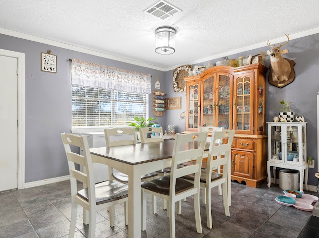 30063 South 4300th Road Stigler, OK 74462 - Photo 8 of 58 Spacious dining area featuring tile flooring, a large window with blinds, and crown molding