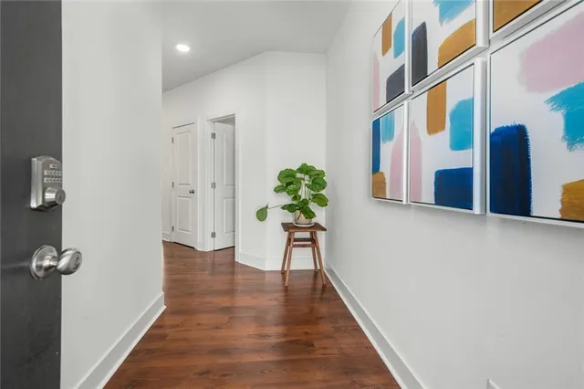 a view of a hallway with wooden floor and a potted plant