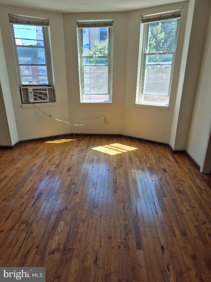 1136 South 13th Street Philadelphia, PA 19147 - Photo 4 of 14 a view of an empty room with wooden floor and a window
