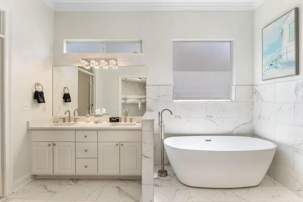 a bathroom with a tub a sink and mirror