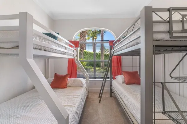 a bedroom with a bed and large window with balcony view