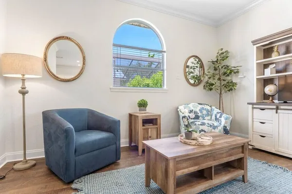 a living room with furniture a chandelier and a mirror