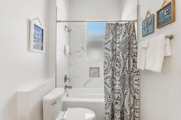 a bathroom with a toilet and shower curtain