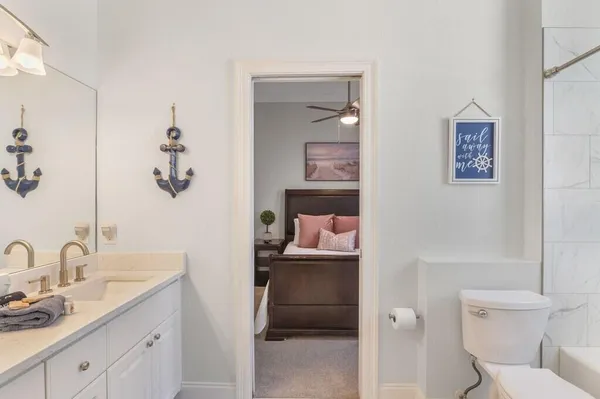 a en suite bathroom with a granite countertop sink and a toilet