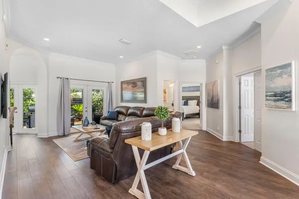 a living room with furniture a wooden floor and a large window