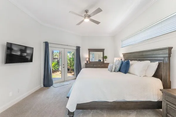 a spacious bedroom with a large bed and a flat tv screen on dresser