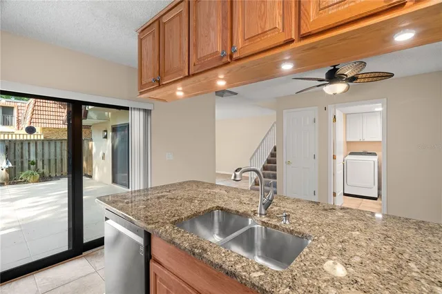 a kitchen with granite countertop a sink a refrigerator and cabinets