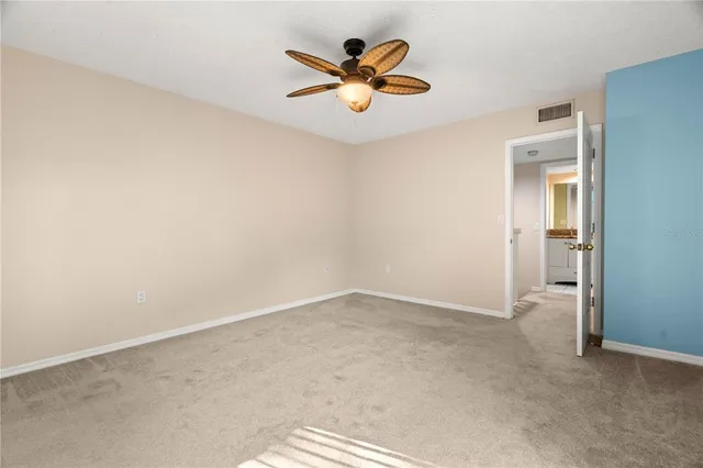 an empty room with closet and ceiling fan