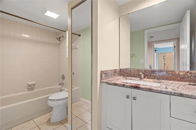 a bathroom with a granite countertop sink a toilet and shower