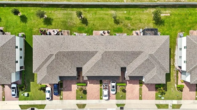 a view of a white house with a yard and potted plants