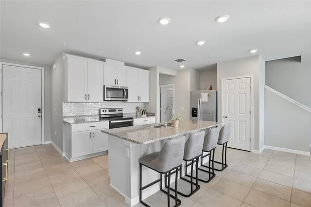a kitchen with a sink stainless steel appliances and white cabinets